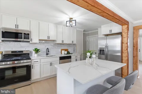 a kitchen with a sink a microwave and cabinets