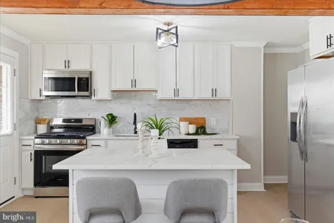 a kitchen with stainless steel appliances a stove a sink a microwave and cabinets