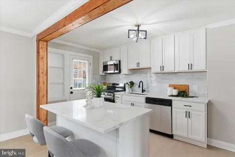 a kitchen with stainless steel appliances granite countertop a sink a stove a refrigerator a microwave and cabinets