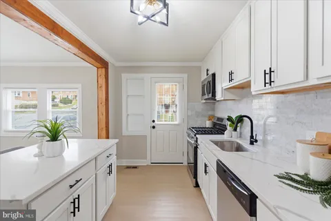 a kitchen with granite countertop a sink stainless steel appliances a counter space and cabinets