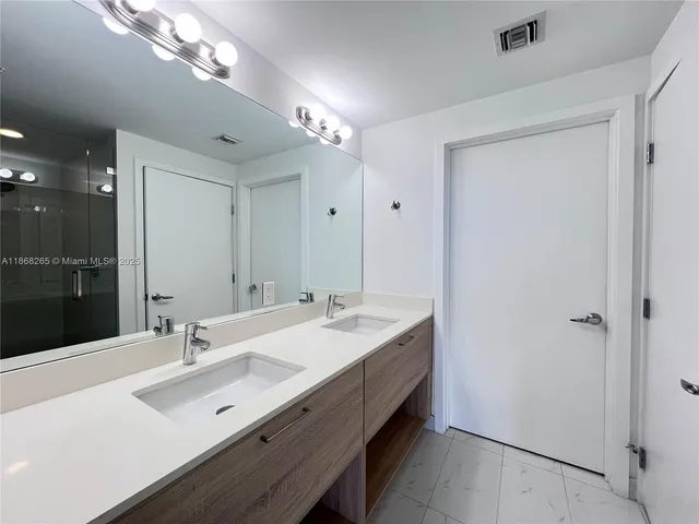 a bathroom with a sink double vanity and a mirror