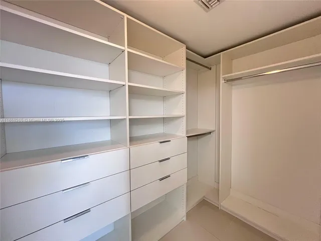 a view of walk in closet with empty racks