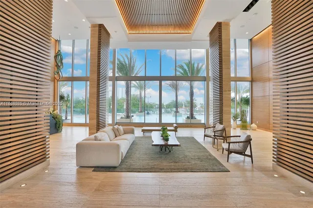 a view of a living room with furniture and floor to ceiling windows