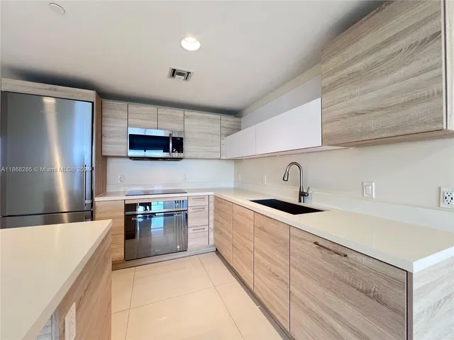 a kitchen with stainless steel appliances granite countertop a sink and a stove