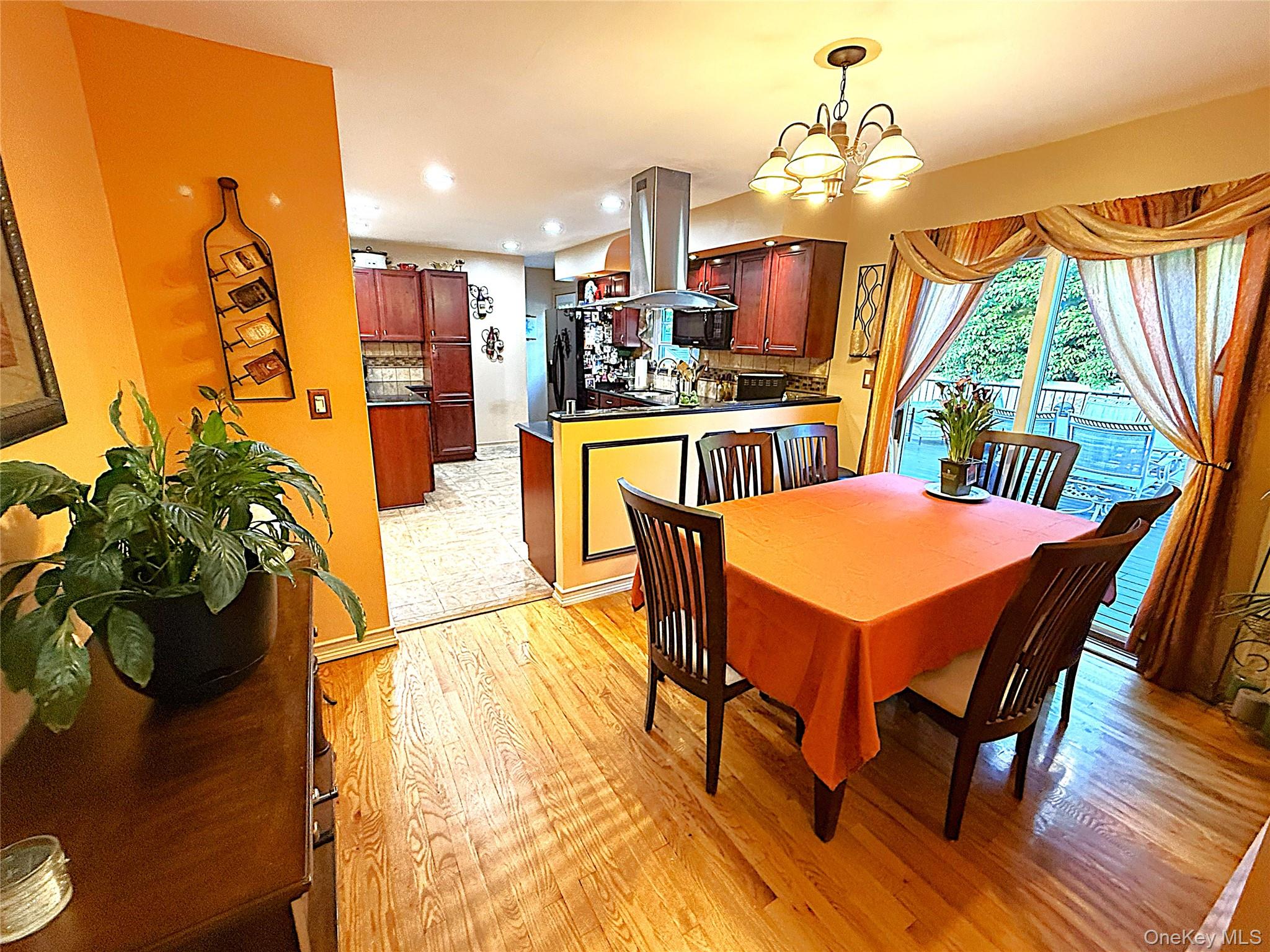 1 Heston Road Shirley, NY 11967 - Photo 16 of 32 Dining area featuring hardwood flooring, a multi-light chandelier, and a sliding glass door providing exterior access