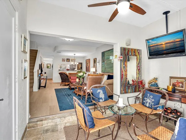 a living room with furniture kitchen view and a window