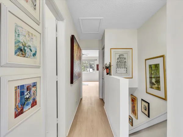 a view of a hallway with wooden floor and dining room