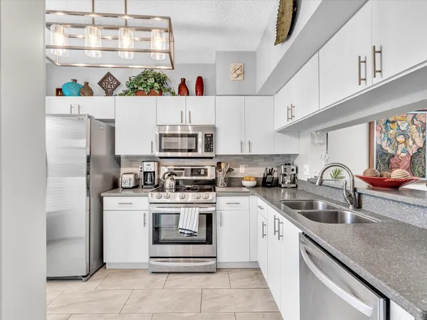a kitchen with stainless steel appliances granite countertop a sink and cabinets