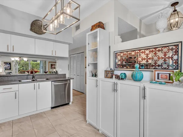 a kitchen with white cabinets and window