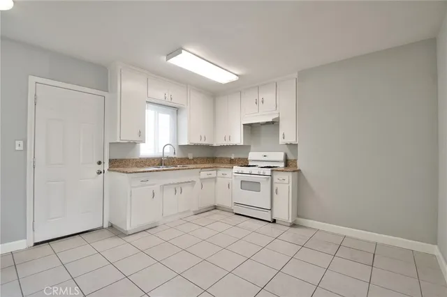 a kitchen with granite countertop white cabinets and white appliances