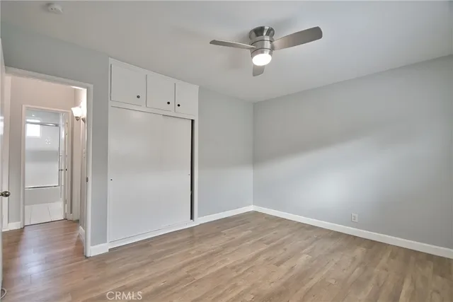 an empty room with wooden floor and mirror