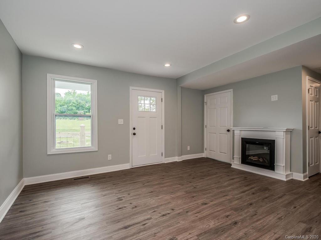 2096 Hardin Strait Road Chester, SC 29706 - Photo 6 of 27 an empty room with wooden floor a fireplace and windows