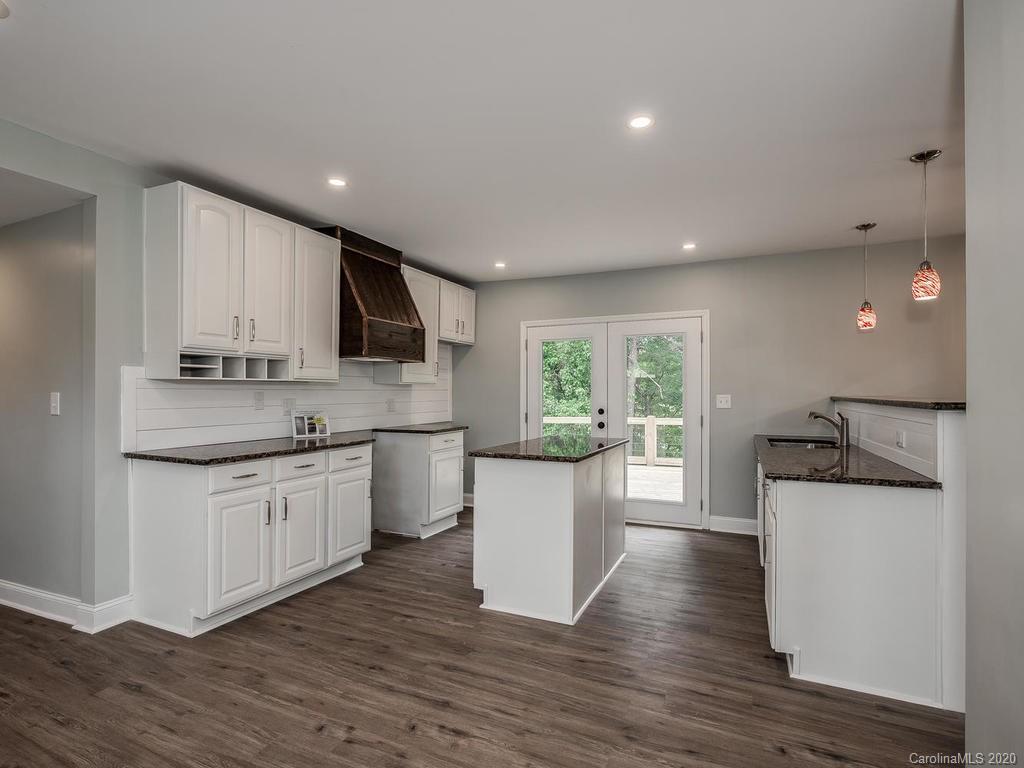 2096 Hardin Strait Road Chester, SC 29706 - Photo 7 of 27 a kitchen with a sink wooden floor and white cabinets