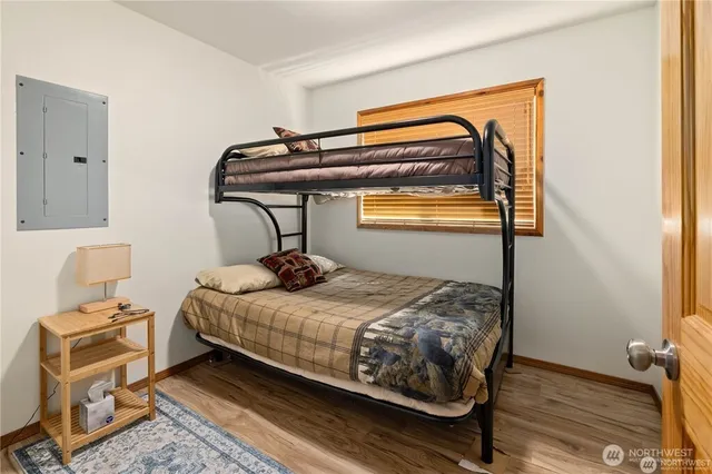 a bedroom with a bed and wooden floor