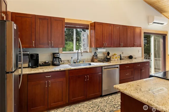 a kitchen with stainless steel appliances granite countertop wooden cabinets a sink and dishwasher