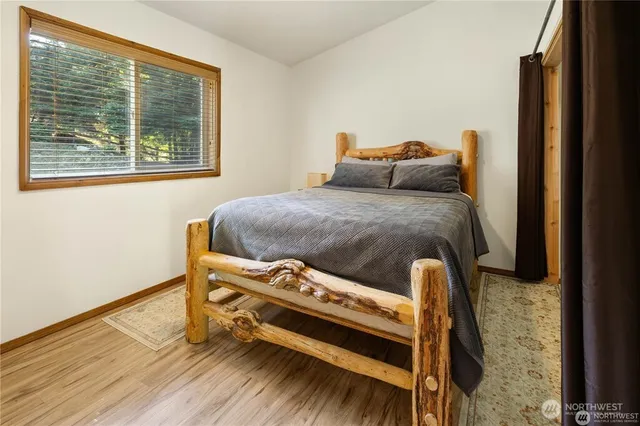 a bedroom with a bed and wooden floor