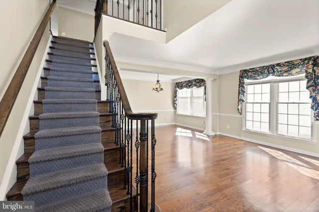 a view of a hallway with wooden floor and staircase