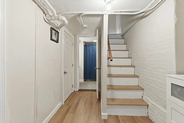a view of a hallway with wooden floor and staircase