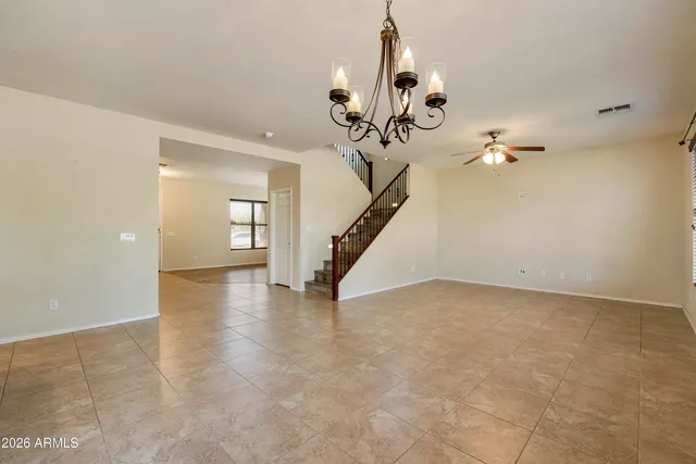 a view of a room with a chandelier fan and wooden floor