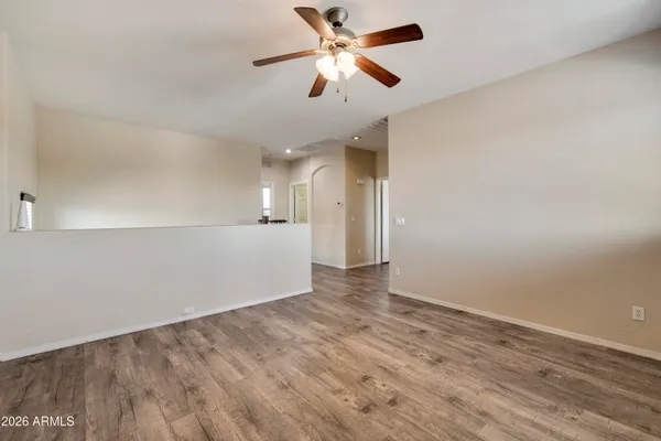 a view of an empty room and kitchen view