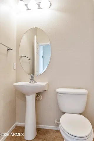 a bathroom with a toilet a sink and a mirror