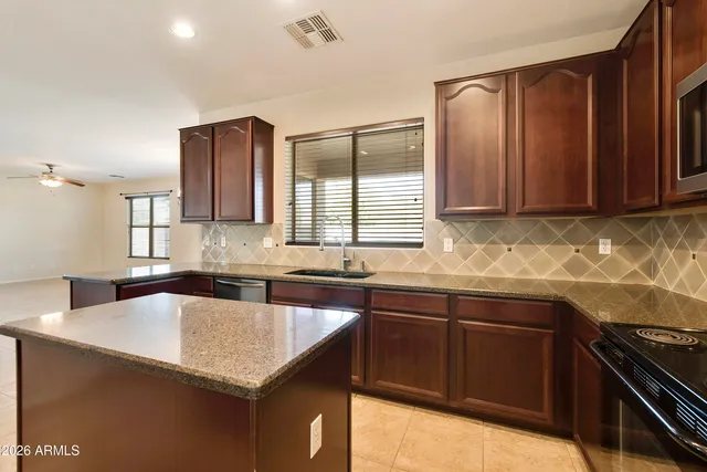 a kitchen with granite countertop a sink and a stove