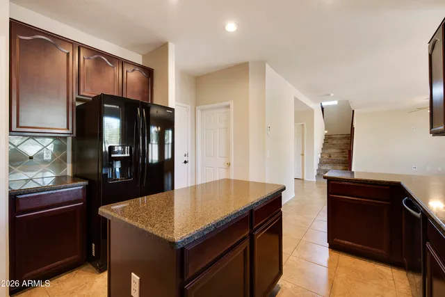 a kitchen with stainless steel appliances granite countertop a refrigerator and a stove top oven