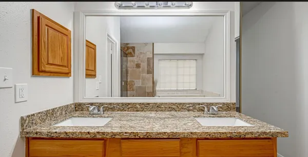 a bathroom with a granite countertop sink and a mirror