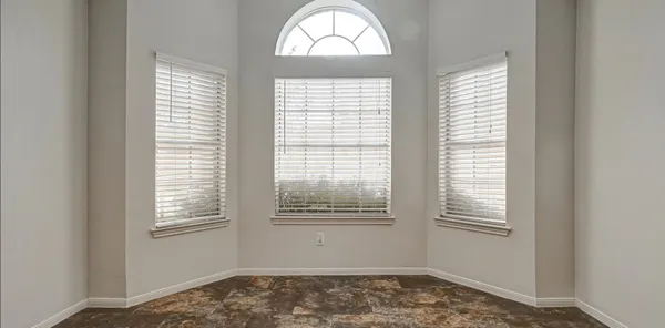 a view of an empty room with window and fire place