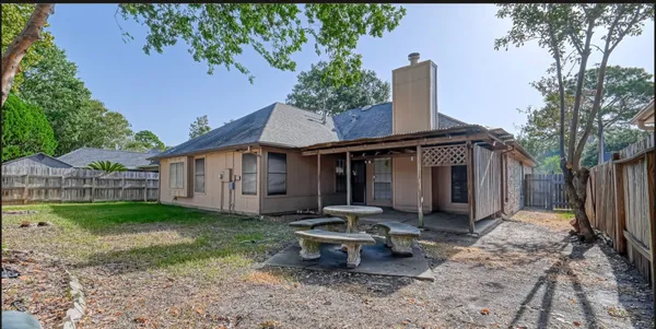 a view of backyard with table and chairs and wooden fence