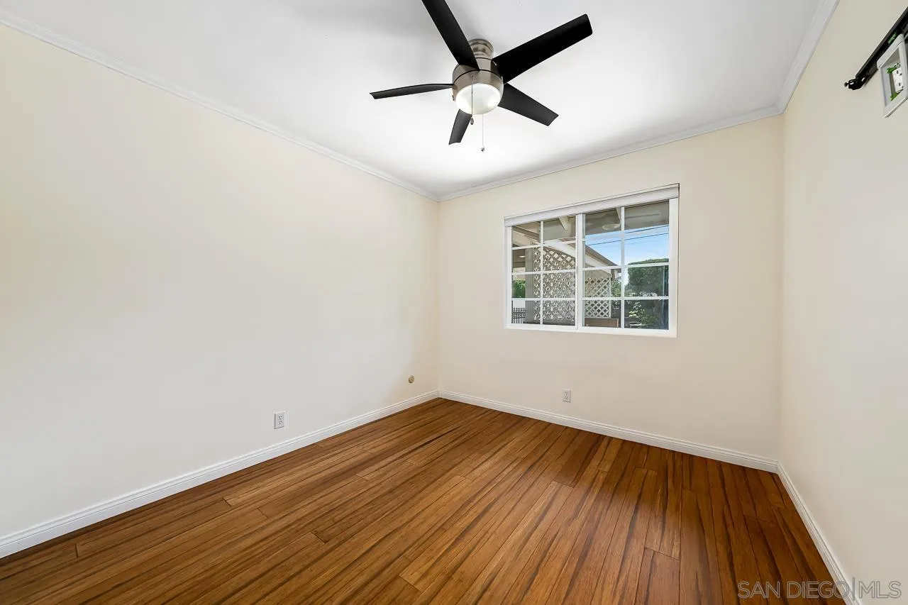 13610 Putney Road Poway, CA 92064 - Photo 26 of 62 an empty room with wooden floor chandelier fan and windows