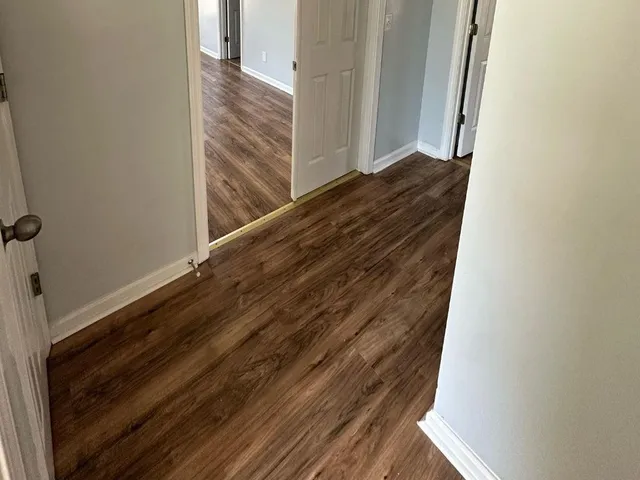 a view of wooden floor and staircase in a hall with wooden floor