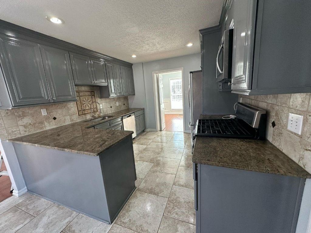 1261 Lakeview Road Grayson, GA 30017 - Photo 32 of 35 a kitchen with kitchen island granite countertop a sink stove and cabinets