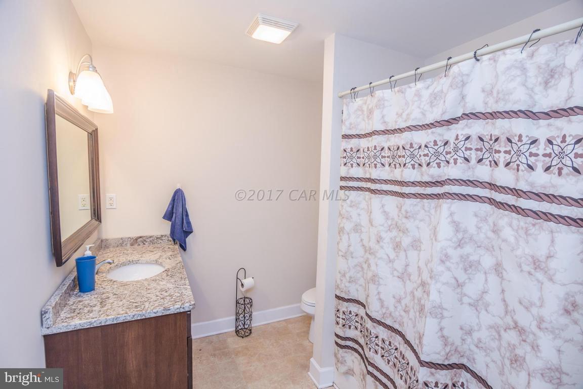 29632 Deal Island Road Princess Anne, MD 21853 - Photo 25 of 33 a bathroom with a granite countertop sink and a mirror