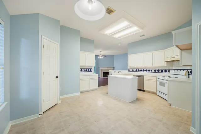 a kitchen with a refrigerator and white cabinets