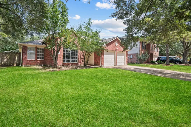 a front view of a house with a garden and trees