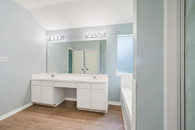 a spacious bathroom with a double vanity sink and mirror