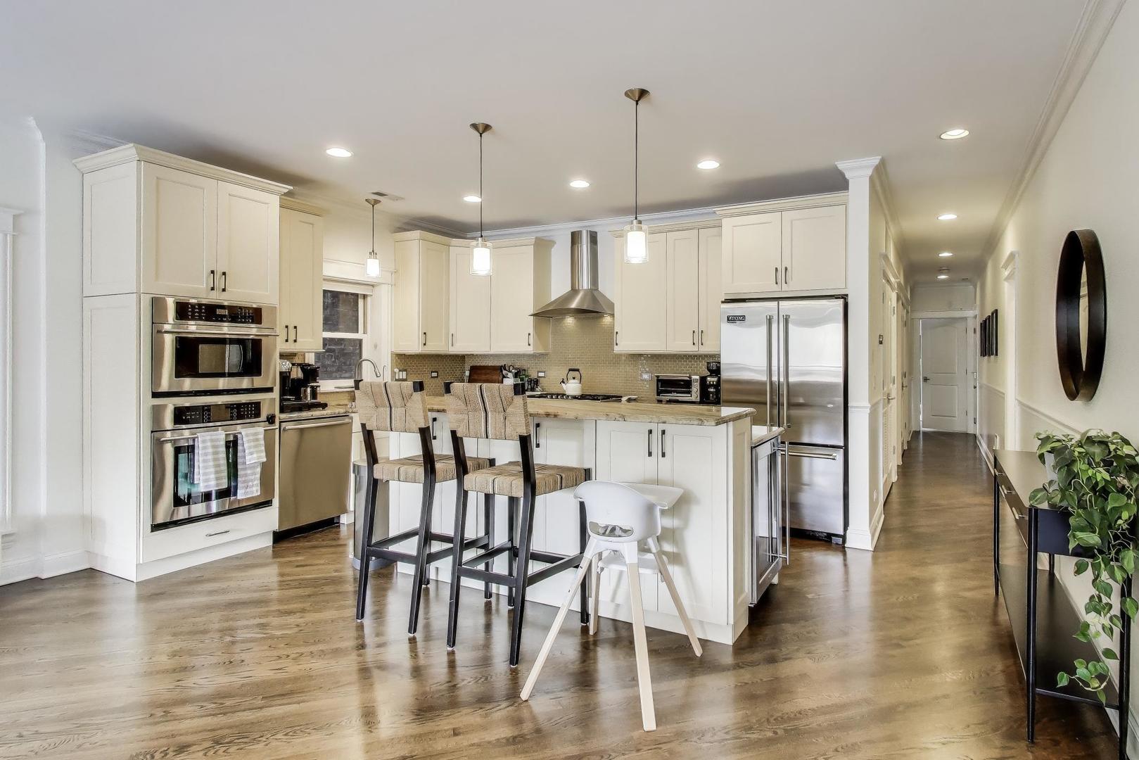 456 West Briar Place, Unit 2 Chicago, IL 60657 - Photo 9 of 25 a kitchen with stainless steel appliances kitchen island granite countertop a refrigerator and a stove top oven