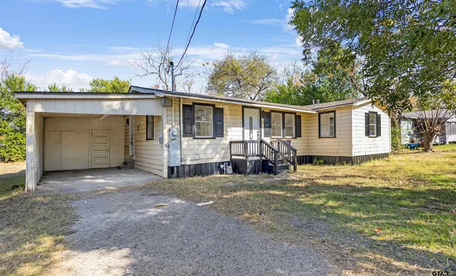 a view of a house with a big yard and large tree