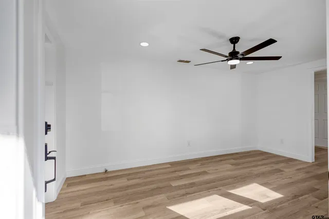 a view of a big room with wooden floor and a ceiling fan