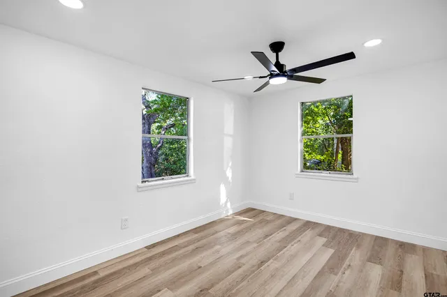 an empty room with a window and a fan