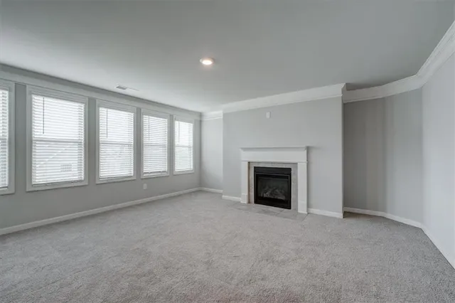 an empty room with fireplace and windows