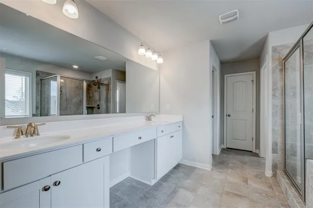 a spacious bathroom with a granite countertop sink mirror and cabinets