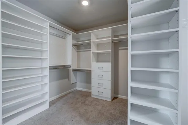 a view of walk in closet with empty racks