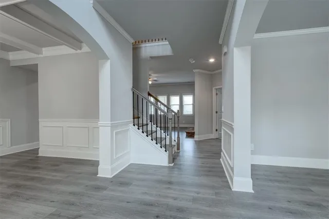 a view of a hallway with wooden floor and stairs