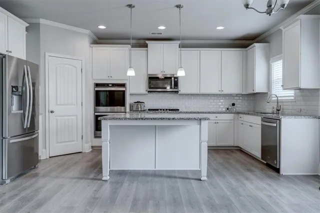 a kitchen with a refrigerator and a stove top oven