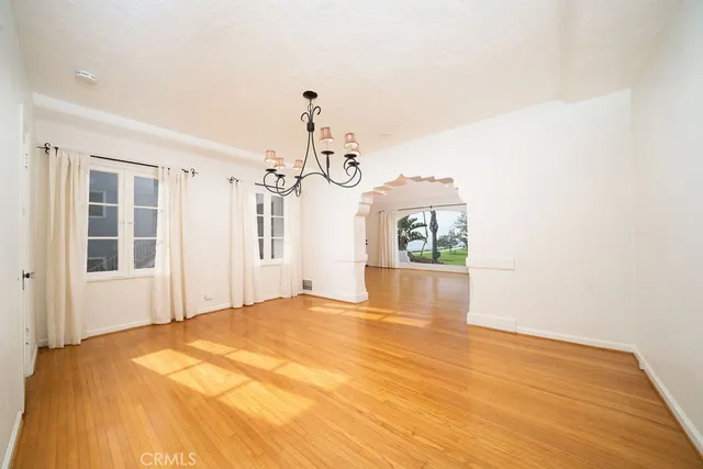 a view of a bedroom with wooden floor and windows