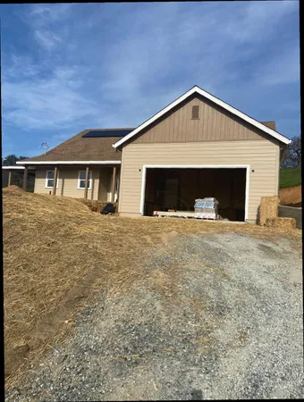 a view of house with yard and garage