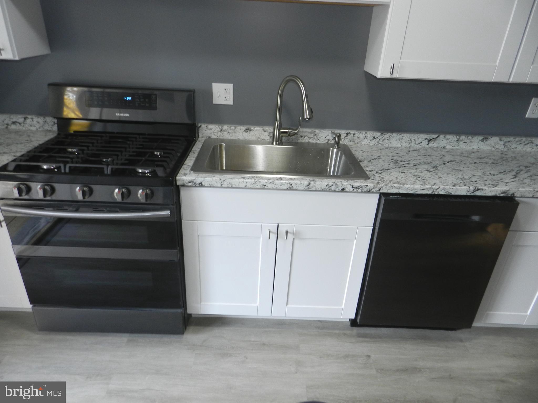 1533 Gleneagle Road Baltimore, MD 21239 - Photo 8 of 32 a kitchen with granite countertop a stove and a sink