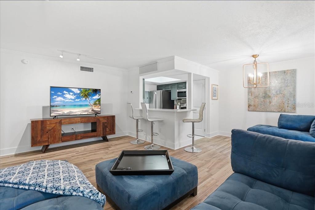 8911 Blind Pass Road, Unit 118 St. Pete Beach, FL 33706 - Photo 14 of 34 a living room with furniture and a flat screen tv